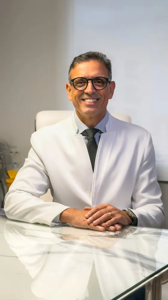 Dr. Bruno Lameiras, ortopedista, sorrindo em seu consultório